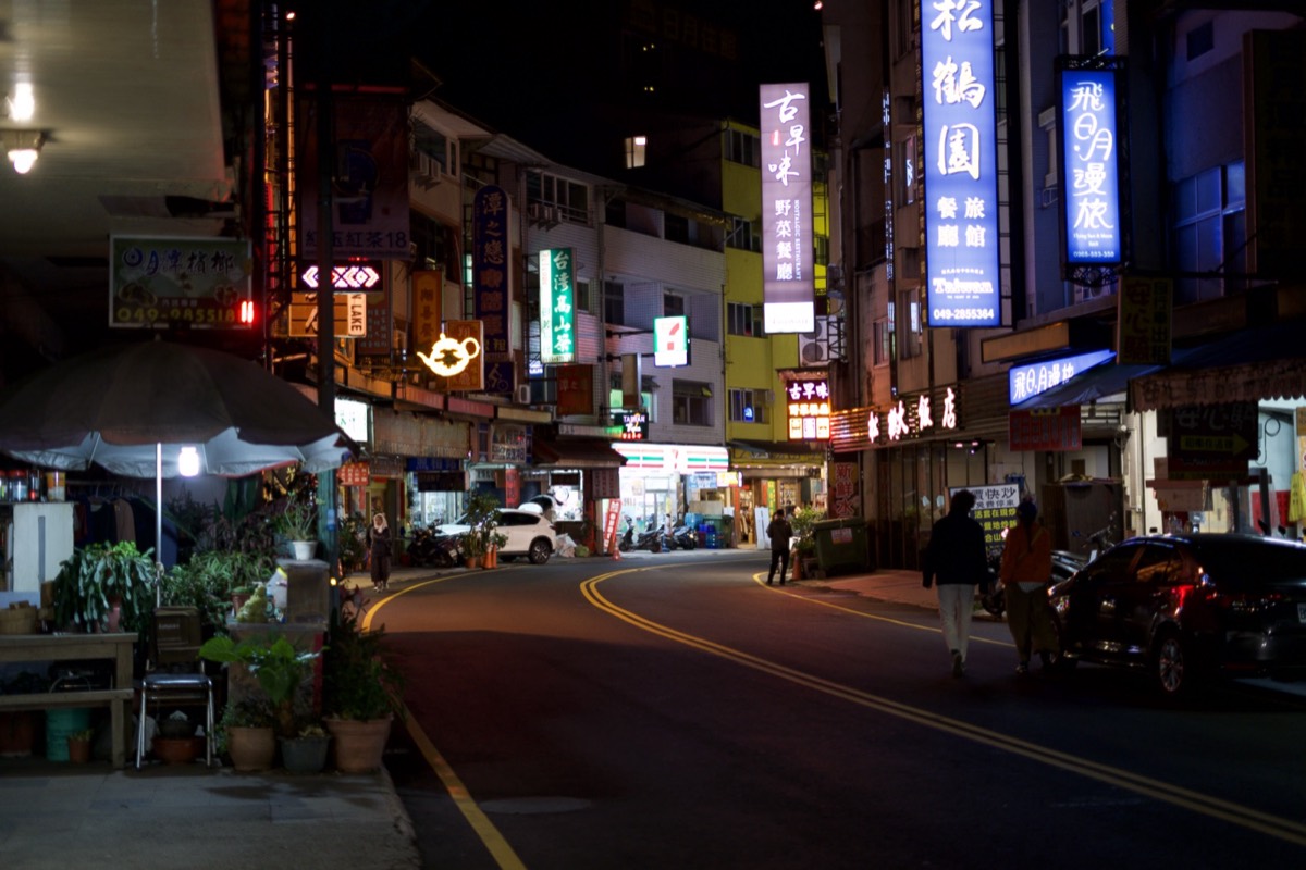 Neon-lit street at night, the signs bright to the point of blowing out